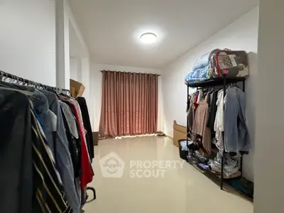 Spacious storage room with clothing racks and natural light