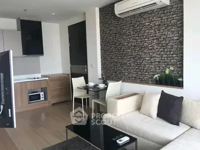 Modern living room with stylish brick accent wall and cozy furniture in open layout apartment.