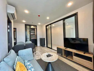 Modern living room with sleek furniture and large TV, perfect for relaxation and entertainment.