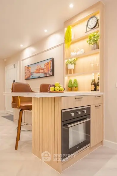 Modern kitchen with stylish open layout and built-in oven, featuring elegant lighting and decor.