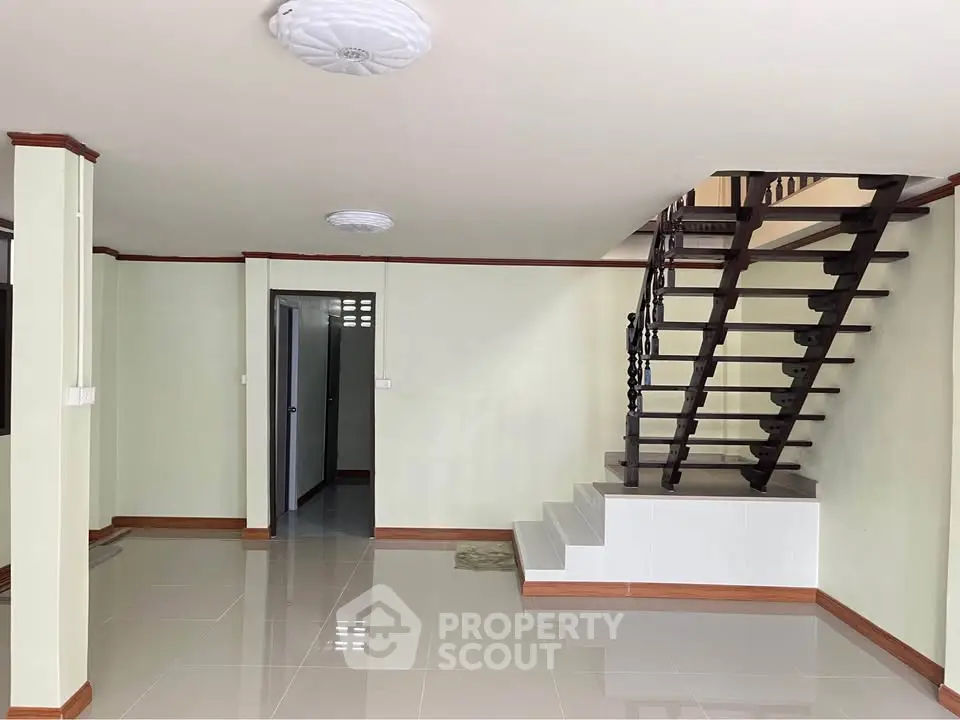 Spacious interior with modern staircase and glossy tiled flooring, perfect for stylish living.