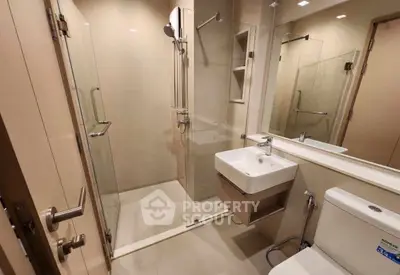 Modern bathroom with glass shower enclosure and sleek fixtures
