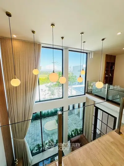 Stunning modern living room with high ceilings and large windows offering a scenic view.