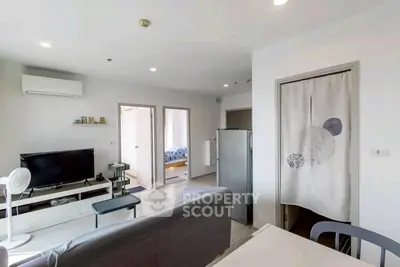 Modern living room with TV, air conditioning, and stylish decor in open layout apartment.