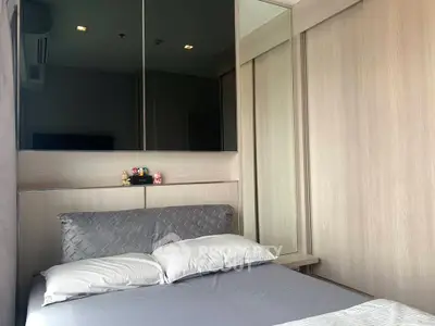 Cozy bedroom with modern wooden paneling and mirrored wardrobe