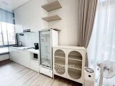 Modern kitchen with sleek cabinetry and large windows for natural light