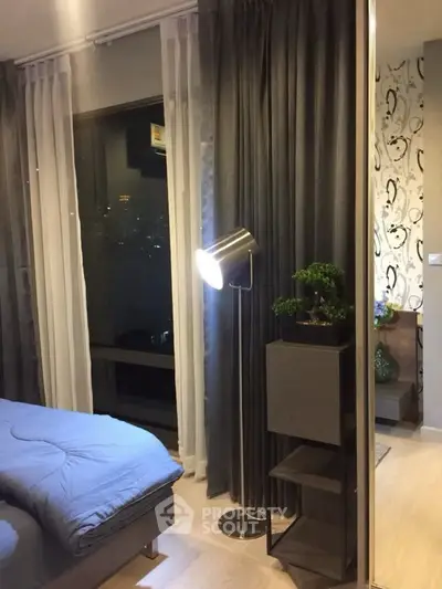 Modern bedroom with stylish decor and city view, featuring elegant lighting and contemporary furnishings.