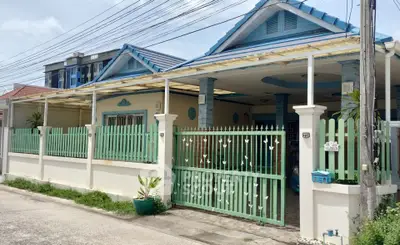 Charming single-story home with pastel blue accents and gated entrance in a serene neighborhood.
