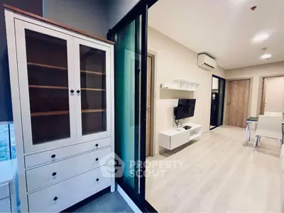 Modern living room with sleek furniture and glass cabinet