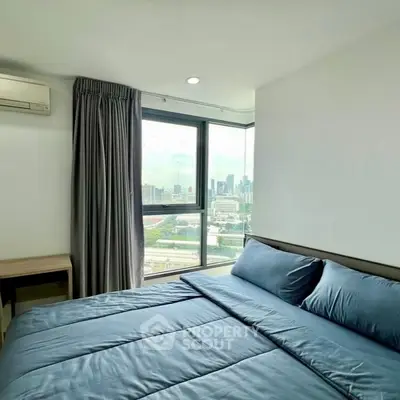 Modern bedroom with city view, featuring a cozy bed and large window.
