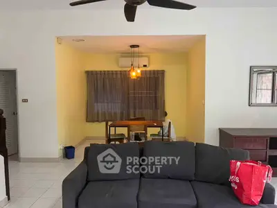 Spacious living room with modern furniture and ceiling fan, ideal for comfortable living.