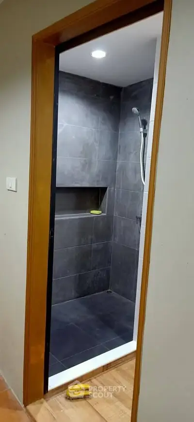 Modern bathroom with sleek shower design and dark tiles