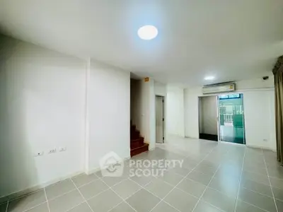 Spacious modern living room with tiled flooring and natural light