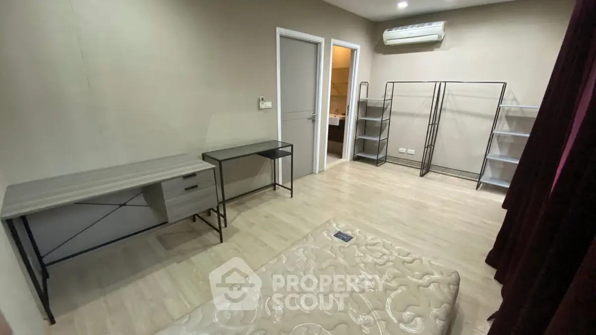 Spacious bedroom with modern minimalist design and ample storage space.
