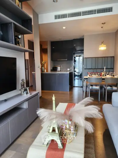 Modern living room with open kitchen, stylish decor, and elegant dining area in a contemporary apartment.