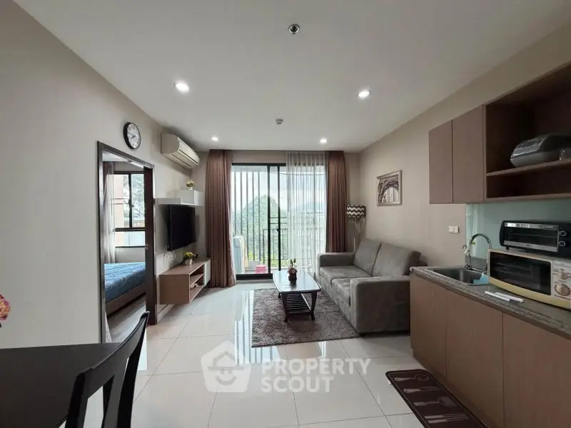 Modern open-plan living room with kitchen and balcony view