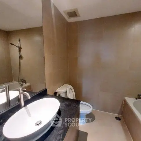 Modern bathroom with sleek fixtures and a bathtub in a contemporary home.