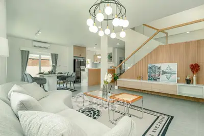 Modern open-plan living room with stylish decor and staircase