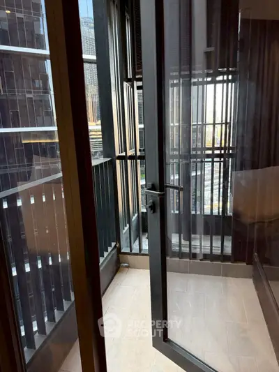 Modern apartment balcony with city view and sleek glass door
