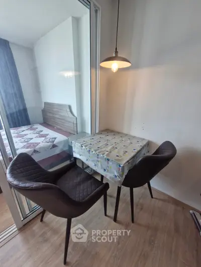 Cozy dining nook with modern chairs and pendant light in stylish apartment