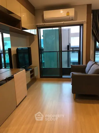 Modern living room with sleek furniture and balcony access in urban apartment.