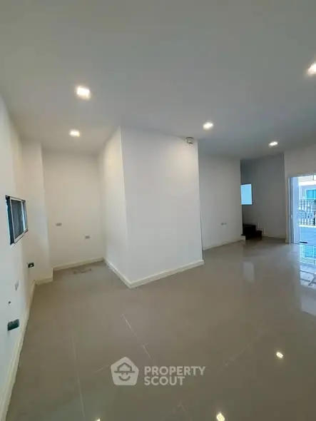 Spacious modern living room with sleek tile flooring and recessed lighting.