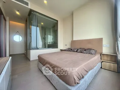 Modern bedroom with glass-walled ensuite bathroom and stylish decor
