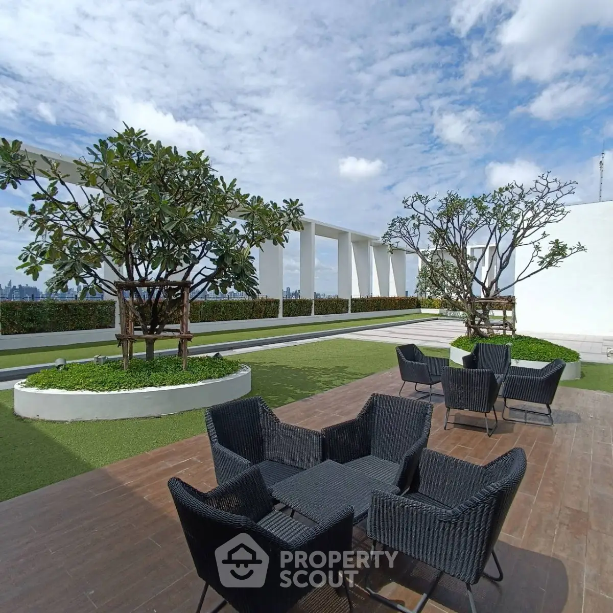 Stunning rooftop terrace with modern seating and lush greenery, offering panoramic city views.