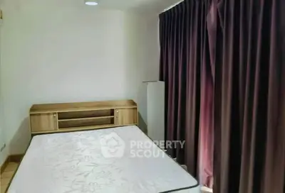 Cozy bedroom with wooden furniture and dark curtains, perfect for restful nights.