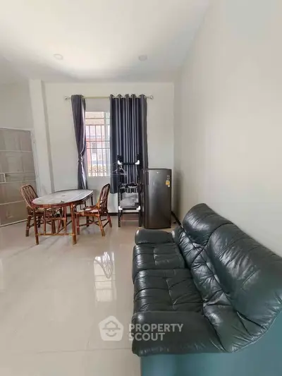 Spacious living room with modern furniture and natural light, perfect for relaxation and entertaining.