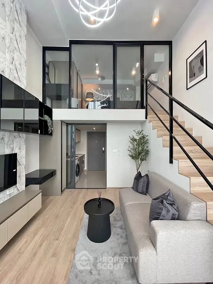 Modern duplex living room with stylish decor and mezzanine level, featuring sleek staircase and contemporary furniture.