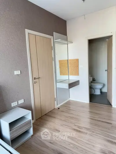 Modern bedroom with ensuite bathroom and stylish wooden flooring