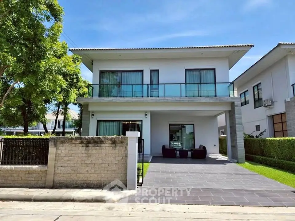 Modern two-story house with large windows and spacious driveway in a serene neighborhood.