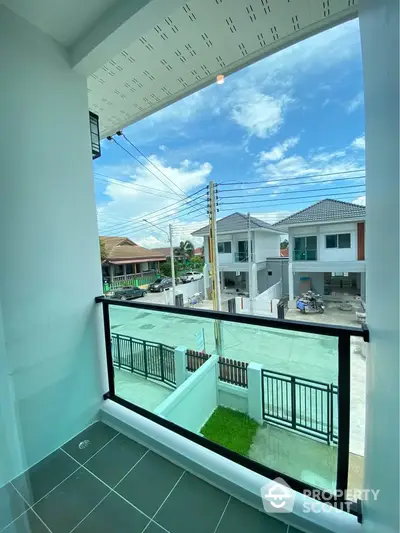 Charming balcony with a view of modern suburban homes and clear blue sky.