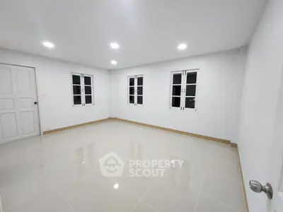 Spacious empty room with tiled floor and bright lighting, ideal for customization.