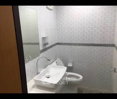 Modern bathroom with sleek white fixtures and stylish tile design.