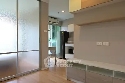 Modern apartment interior with open layout, featuring a compact kitchen and stylish living area.