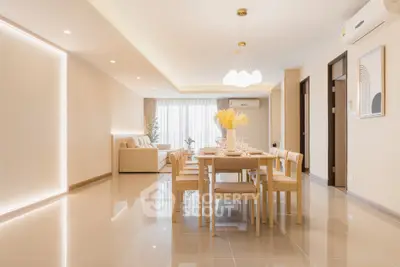 Spacious modern living and dining area with elegant lighting and sleek furniture.