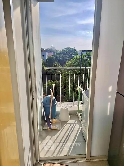 Cozy balcony with lush green view and laundry area