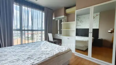 Modern bedroom with large window and stylish furniture in urban apartment