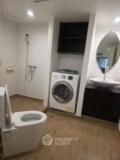 Modern bathroom with washing machine and stylish fixtures in a contemporary apartment.