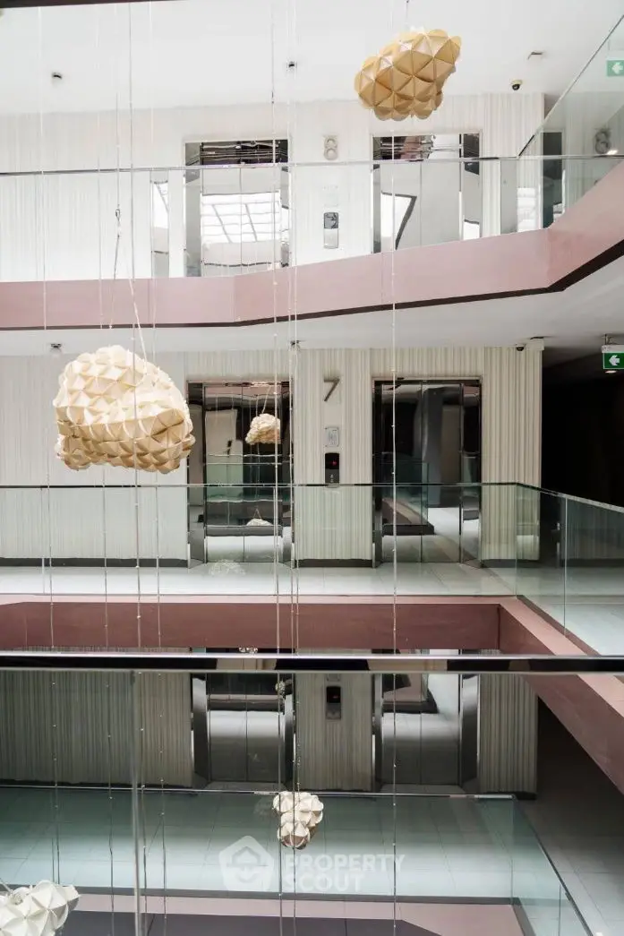 Modern building interior with unique hanging sculptures and glass railings