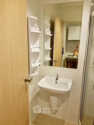 Compact bathroom with modern sink and mirror in cozy apartment