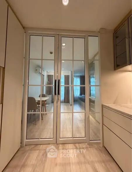 Modern interior with glass doors leading to a stylish dining area and living room.