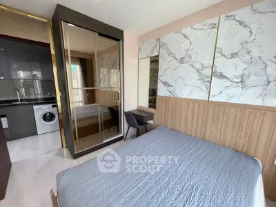 Modern bedroom with stylish decor and in-room washing machine, featuring marble accents and mirrored wardrobe.