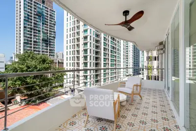 Spacious balcony with modern seating and city view in luxury high-rise apartment.