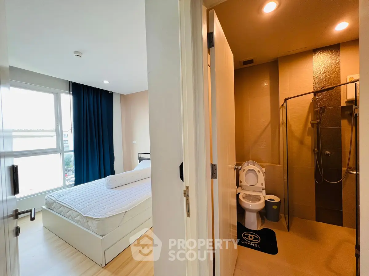 Modern apartment with cozy bedroom and sleek bathroom, featuring large windows and stylish decor.
