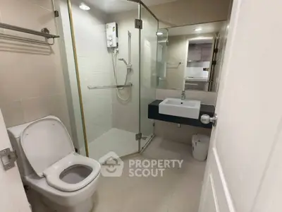 Modern bathroom with glass shower and sleek fixtures in a contemporary apartment.