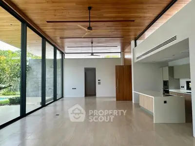 Spacious modern living room with open kitchen and floor-to-ceiling windows