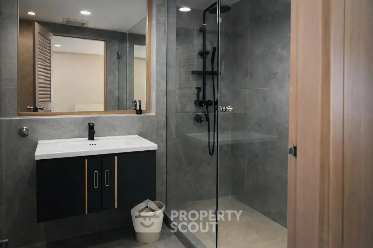 Modern bathroom with sleek shower and stylish vanity in contemporary home.